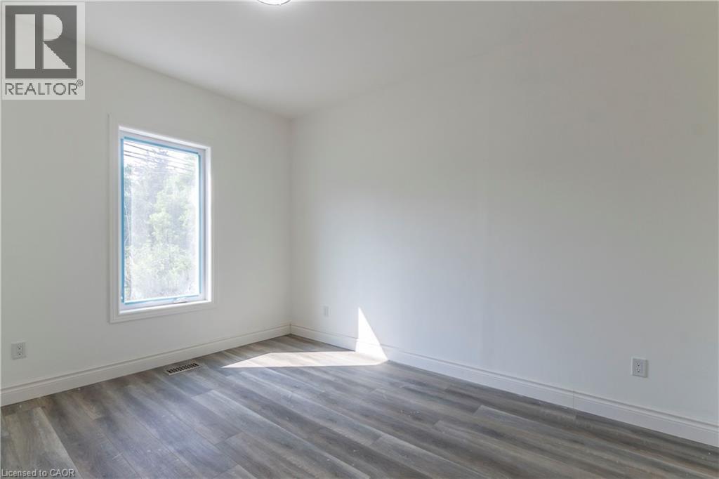Unfurnished room featuring dark wood-style floors and baseboards - 1411 E 56 Highway, Glanbrook, ON - Indoor Photo Showing Other Room