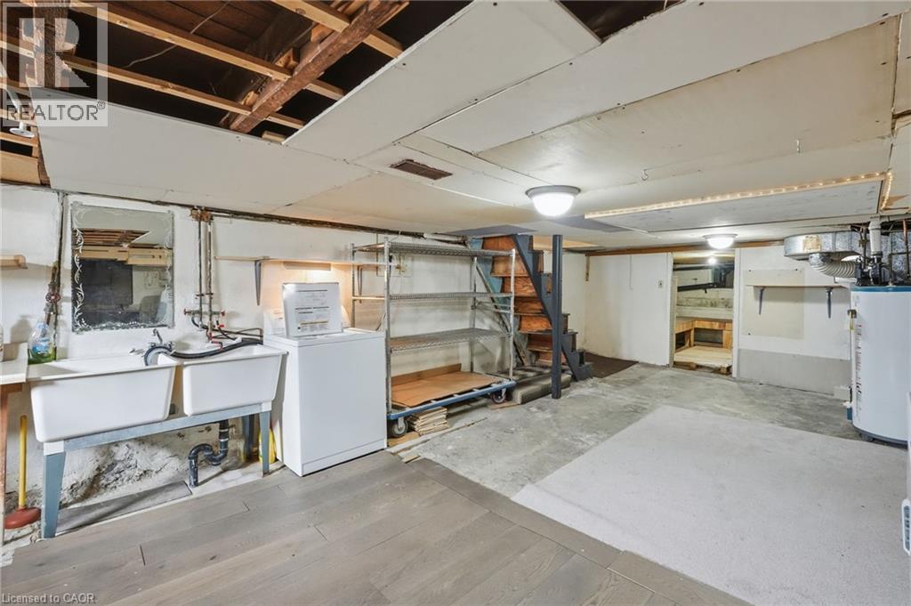 Unfinished basement featuring washer / dryer and water heater - 79 Murray Street E, Hamilton, ON - Indoor