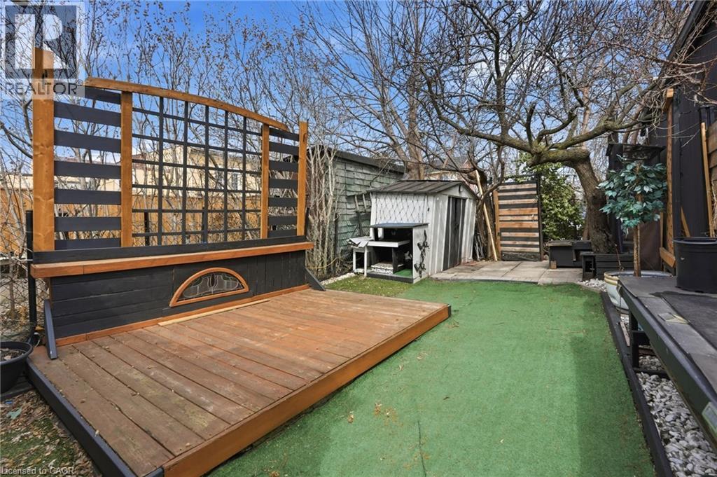 Wooden terrace with a storage shed and a patio area - 79 Murray Street E, Hamilton, ON - Outdoor With Fireplace