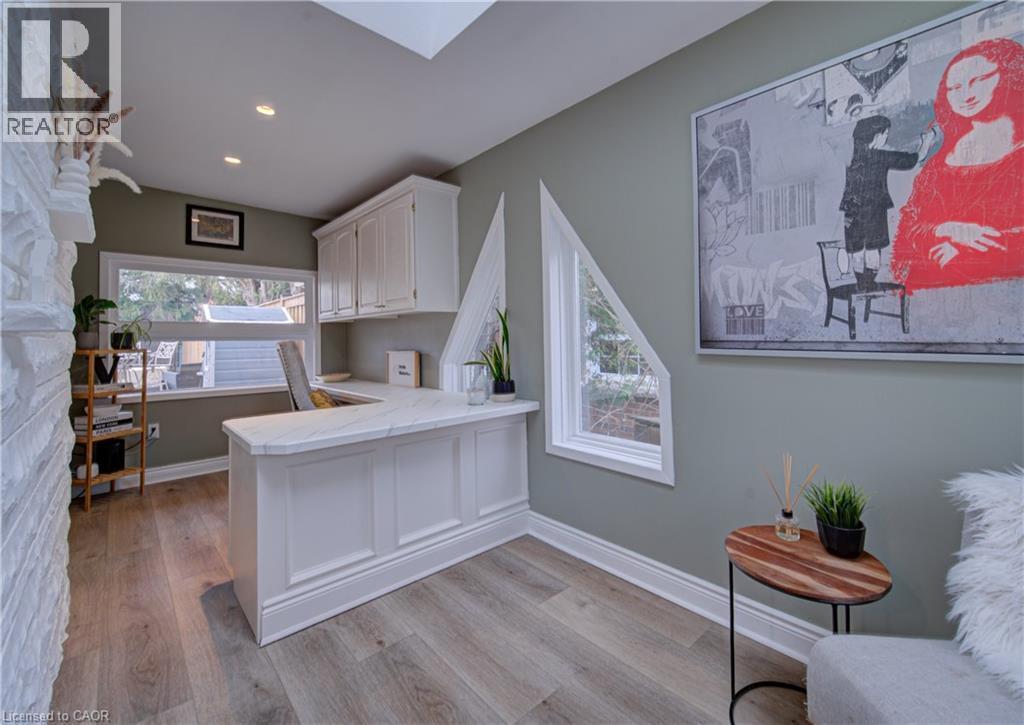 Home office featuring a skylight, dark wood-style flooring, and an accent wall - 655 Ellengale Road, Burlington, ON - Indoor