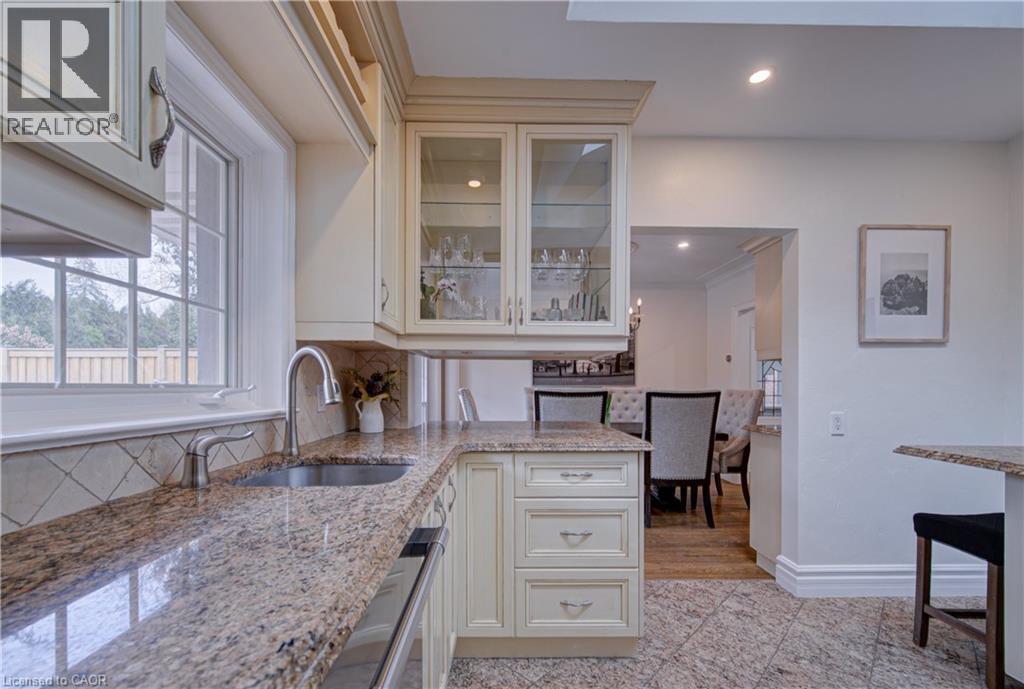Kitchen with glass insert cabinets, granite floors, light stone countertops, recessed lighting, and dishwasher - 655 Ellengale Road, Burlington, ON - Indoor Photo Showing Kitchen