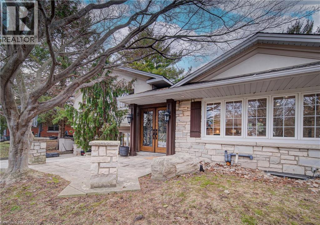 Property entrance featuring a patio area, french doors, and stone siding - 655 Ellengale Road, Burlington, ON - Outdoor