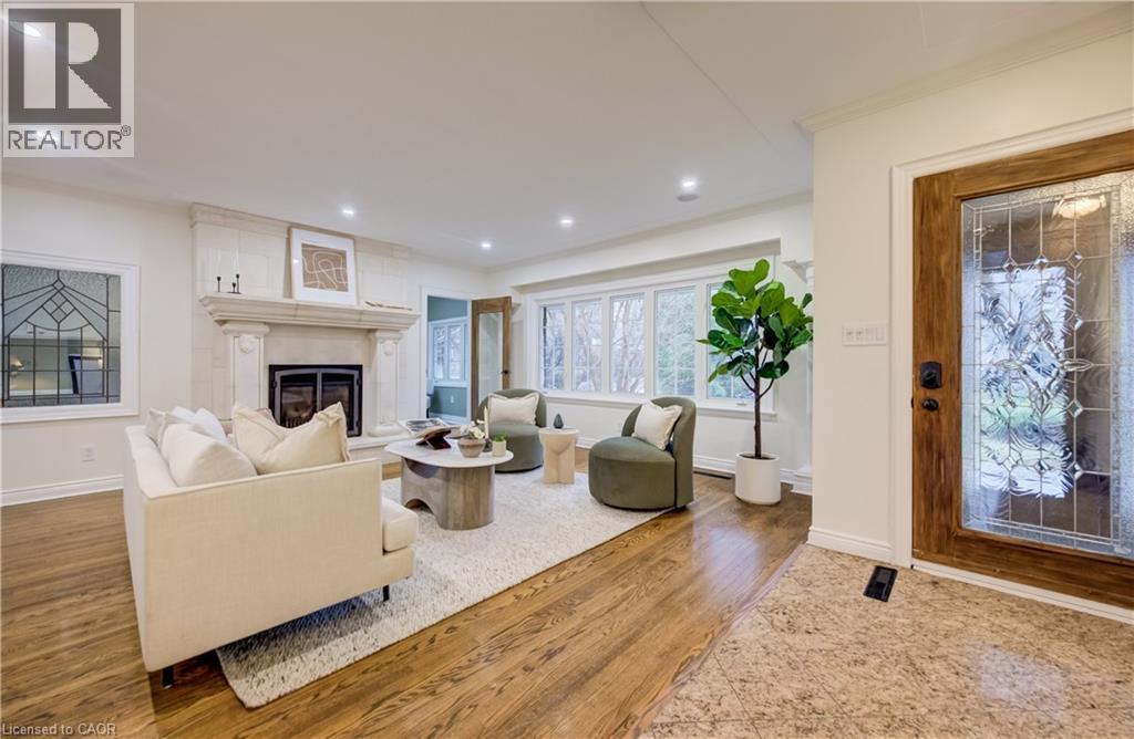 Living room with light wood-type flooring, ornamental molding, a glass covered fireplace, and recessed lighting - 655 Ellengale Road, Burlington, ON - Indoor Photo Showing Living Room With Fireplace