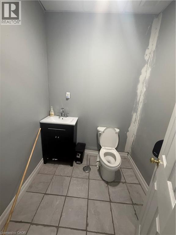 Bathroom with vanity and light tile patterned floors - 10 Sanford Avenue N, Hamilton, ON