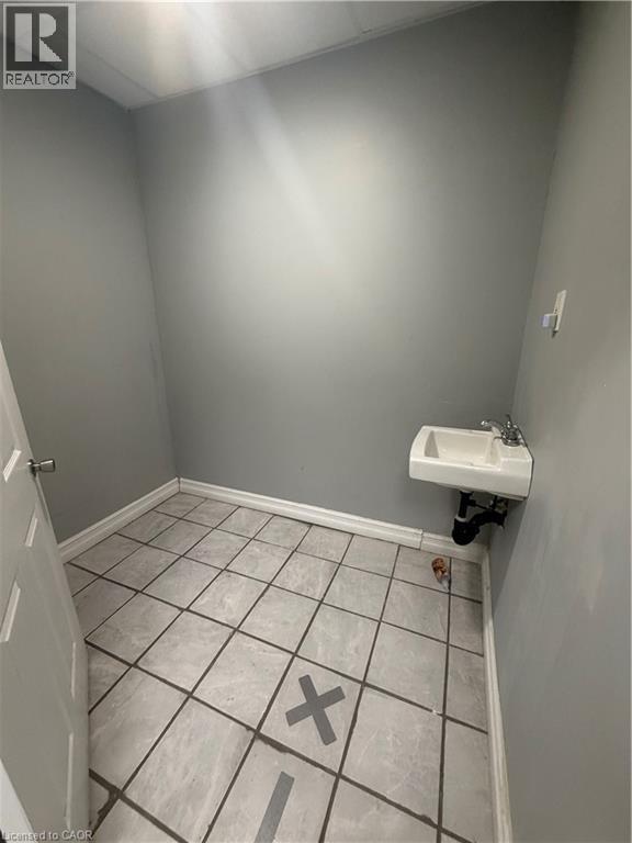 Bathroom featuring light tile patterned floors and a drop ceiling - 10 Sanford Avenue N, Hamilton, ON