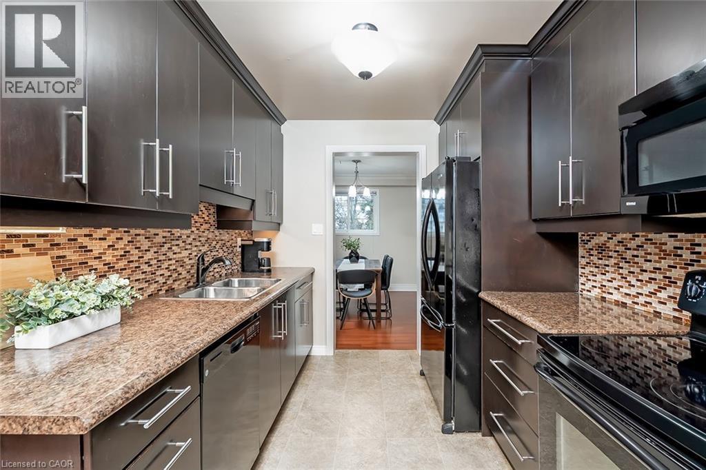 Kitchen with black appliances, backsplash, light tile patterned floors, and light stone countertops - 1278 Consort Crescent, Burlington, ON - Indoor Photo Showing Kitchen With Double Sink With Upgraded Kitchen