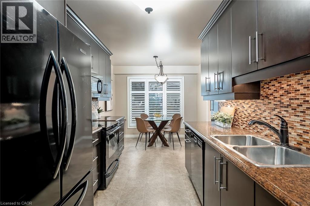 Kitchen featuring black appliances, decorative light fixtures, dark countertops, and backsplash - 1278 Consort Crescent, Burlington, ON - Indoor Photo Showing Kitchen With Double Sink With Upgraded Kitchen