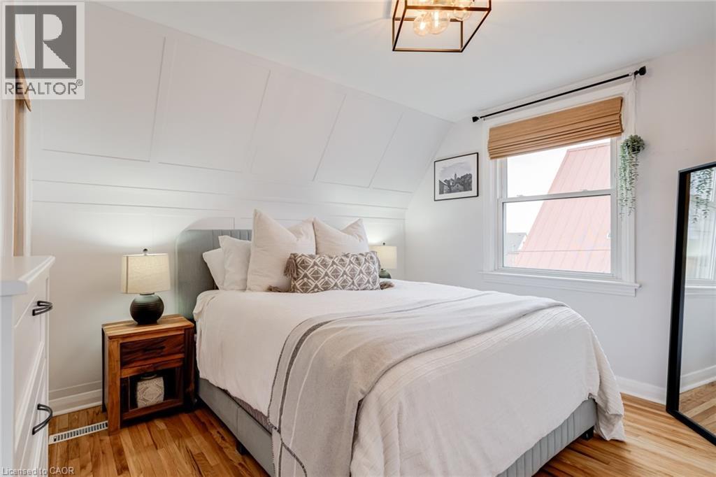 Bedroom with light wood-style floors, vaulted ceiling, and hanging lights - 624 Burgess Avenue, Hamilton, ON - Indoor Photo Showing Bedroom