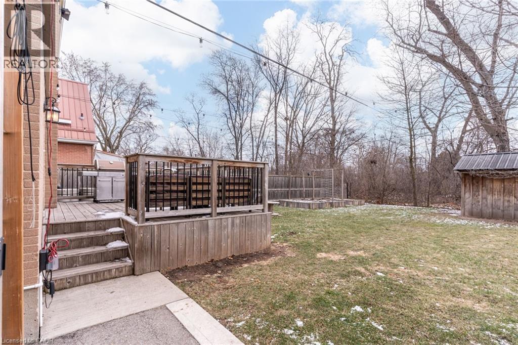 View of green lawn featuring a deck and an outbuilding - 624 Burgess Avenue, Hamilton, ON - Outdoor