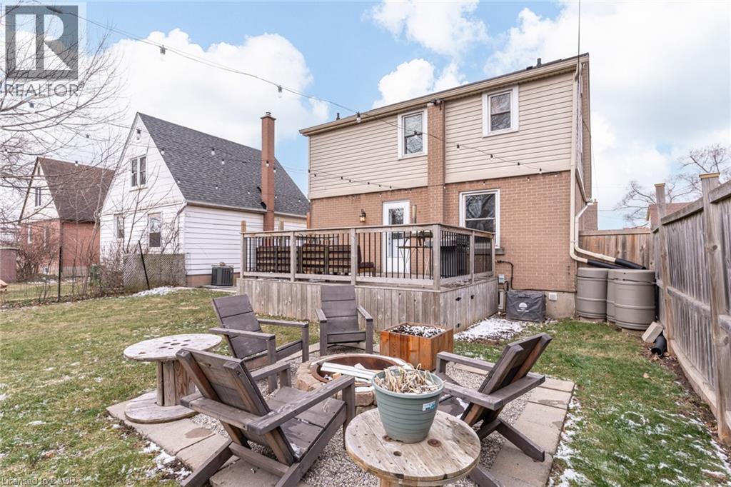 Rear view of property featuring a wooden deck, an outdoor fire pit, a fenced backyard, and brick siding - 624 Burgess Avenue, Hamilton, ON - Outdoor With Deck Patio Veranda With Exterior