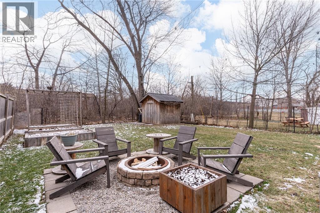 Fenced backyard with a storage unit, a fire pit, and a patio - 624 Burgess Avenue, Hamilton, ON - Outdoor