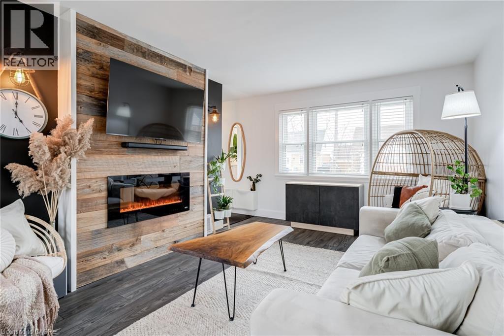 Living area with wood finished floors and a large fireplace - 624 Burgess Avenue, Hamilton, ON - Indoor Photo Showing Living Room With Fireplace
