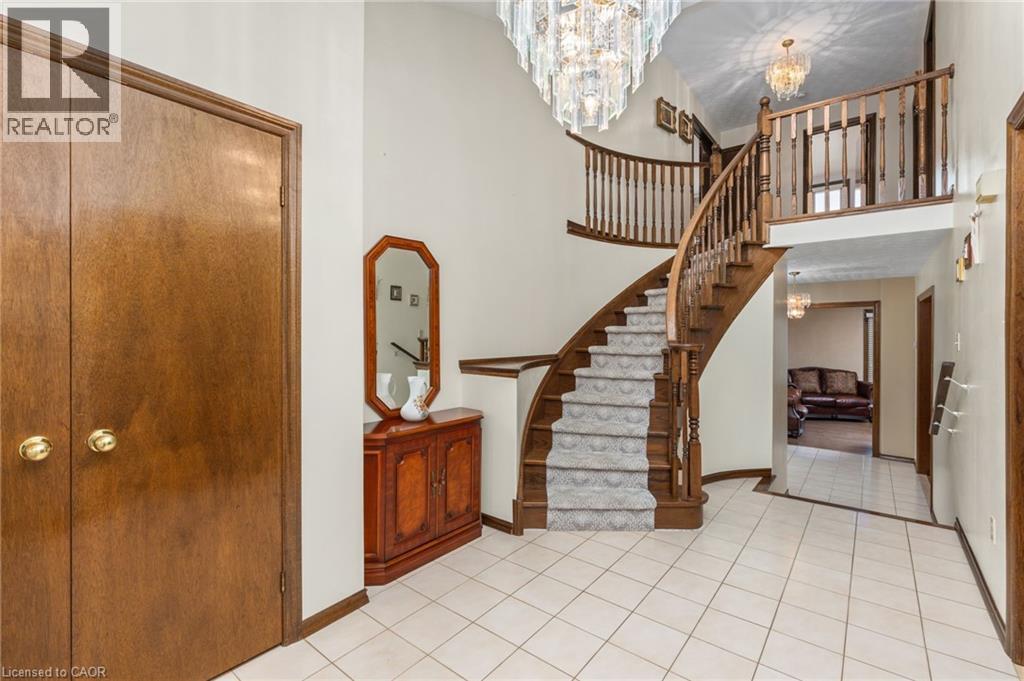 Stairs featuring hanging lights, a high ceiling, and tile patterned floors - 57 Derek Drive, Hamilton, ON - Indoor Photo Showing Other Room