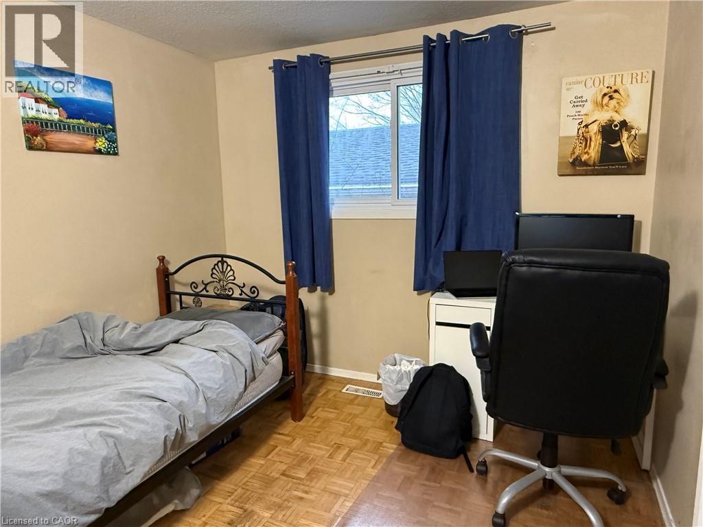 Bedroom featuring parquet flooring, a textured ceiling, and a desk - 60 Helene Crescent, Waterloo, ON - Indoor Photo Showing Bedroom