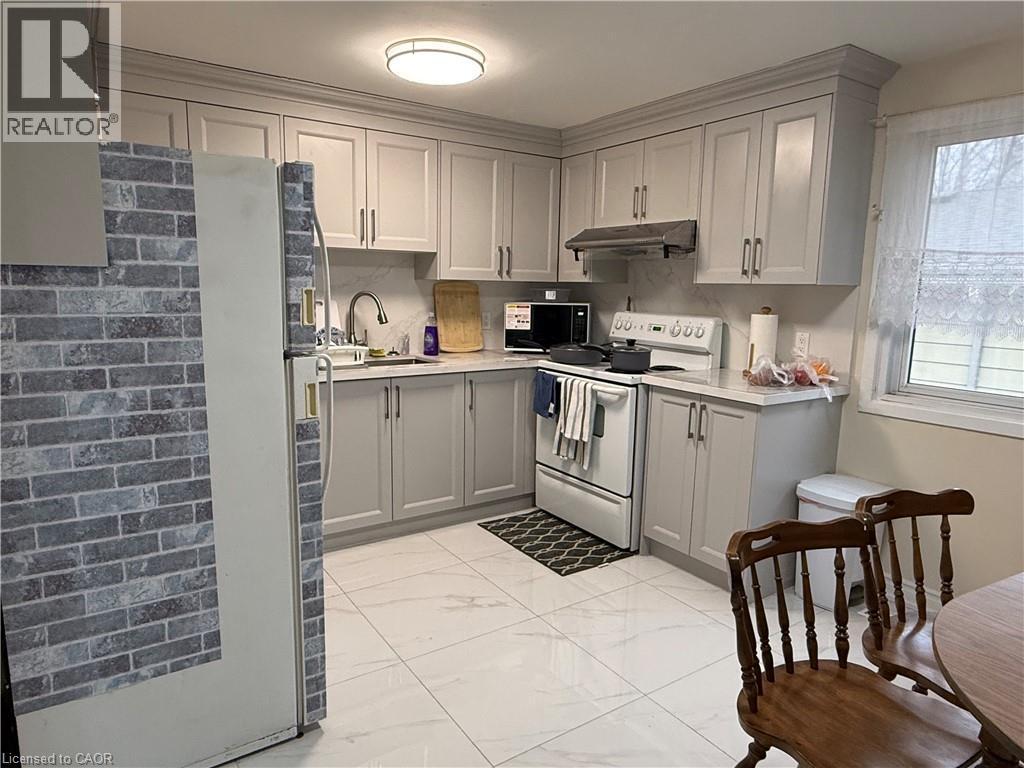 Kitchen featuring gray cabinets, white electric range, light countertops, and freestanding refrigerator - 60 Helene Crescent, Waterloo, ON - Indoor Photo Showing Kitchen