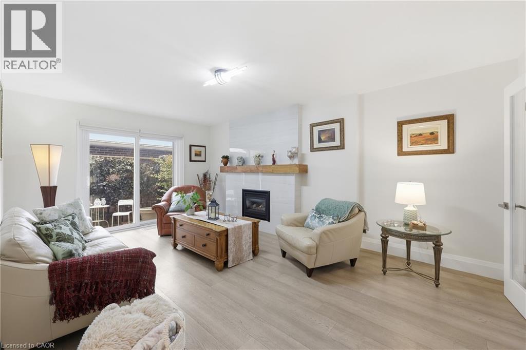 Living room featuring a glass covered fireplace and light wood finished floors - 273 Bryant Crescent, Burlington, ON - Indoor Photo Showing Living Room With Fireplace