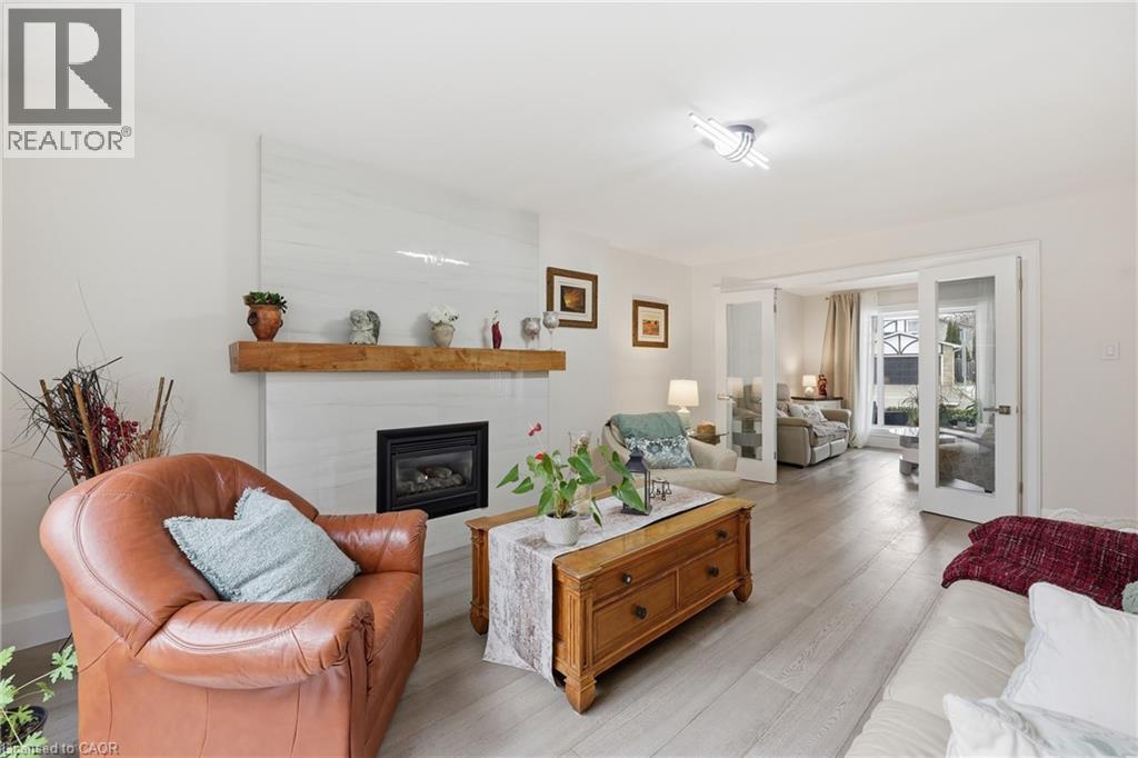 Living area with light wood-style floors and a glass covered fireplace - 273 Bryant Crescent, Burlington, ON - Indoor Photo Showing Living Room With Fireplace