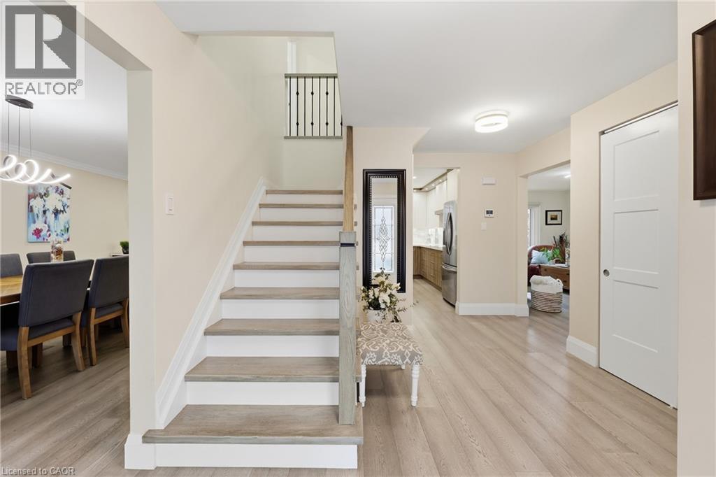 Stairway with wood finished floors and a chandelier - 273 Bryant Crescent, Burlington, ON - Indoor Photo Showing Other Room