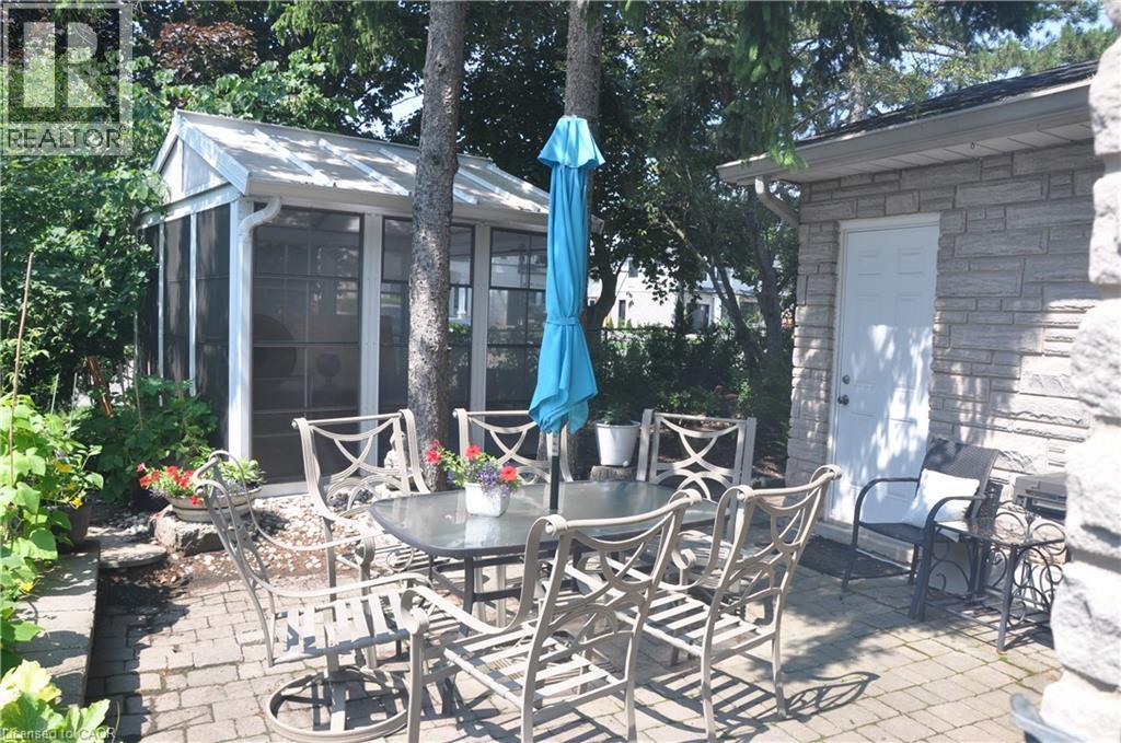 View of patio featuring outdoor dining space and a sunroom - 273 Bryant Crescent, Burlington, ON - Outdoor