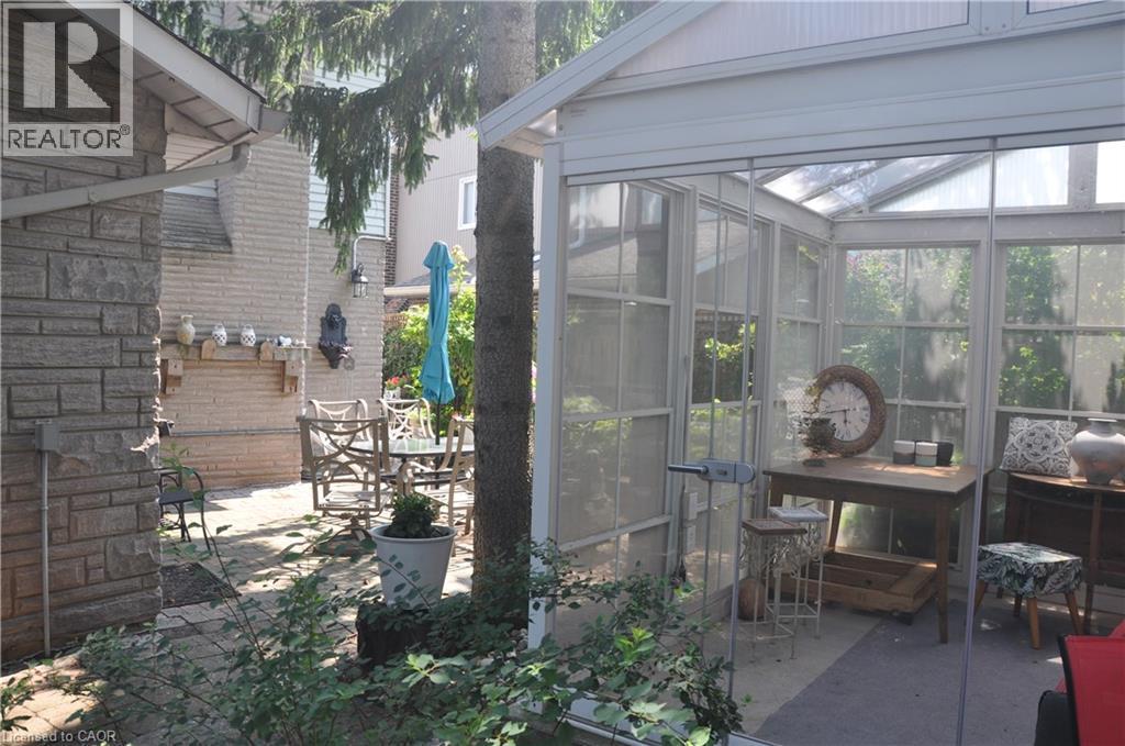 View of patio / terrace with a sunroom and outdoor dining space - 273 Bryant Crescent, Burlington, ON - Outdoor