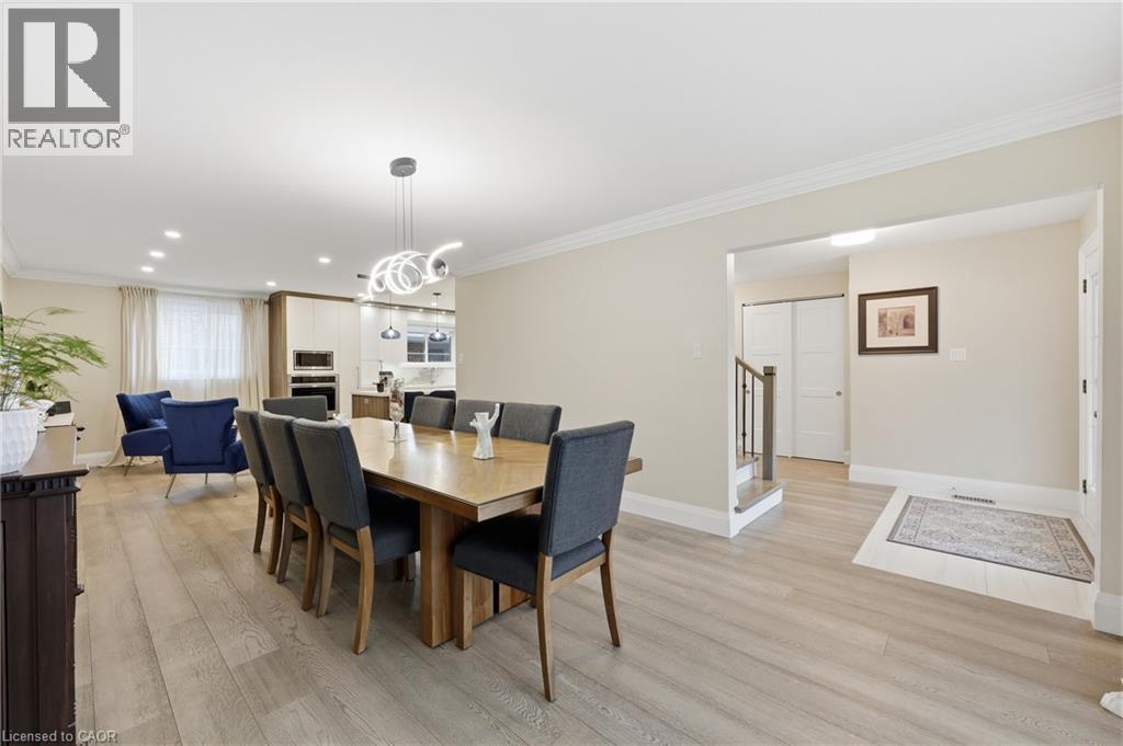 Dining area featuring ornamental molding, light wood finished floors, and a chandelier - 273 Bryant Crescent, Burlington, ON - Indoor Photo Showing Dining Room
