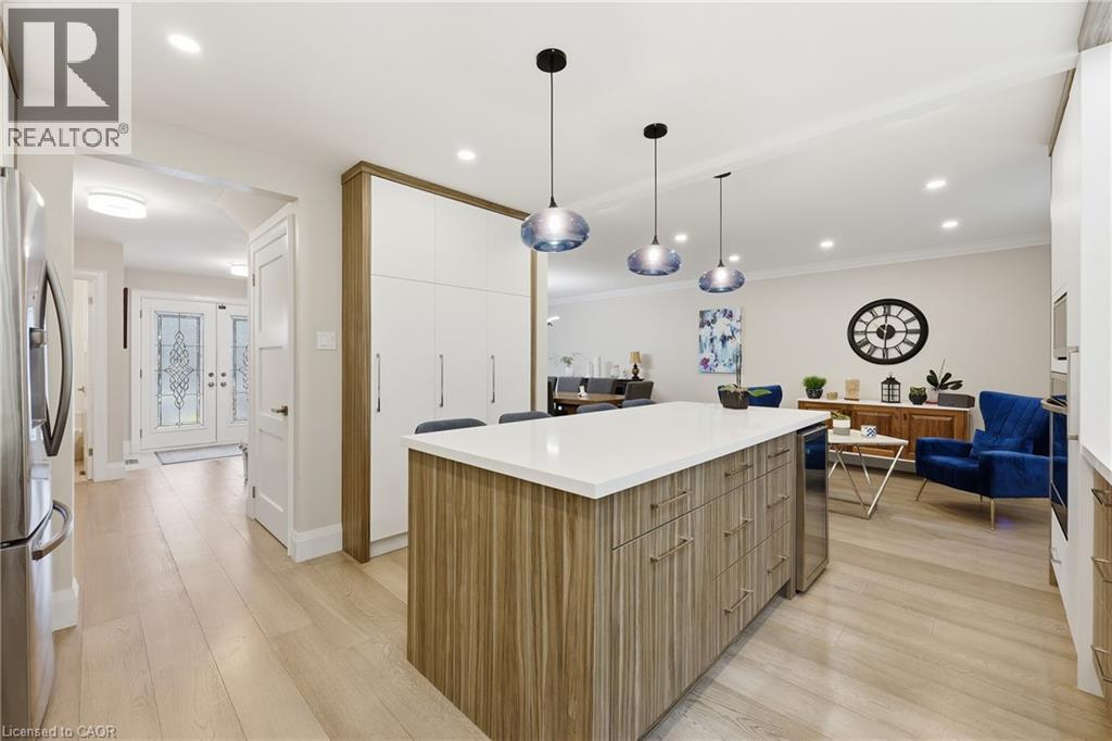 Kitchen with modern cabinets, a center island, light wood finished floors, decorative light fixtures, and stainless steel appliances - 273 Bryant Crescent, Burlington, ON - Indoor Photo Showing Kitchen With Upgraded Kitchen
