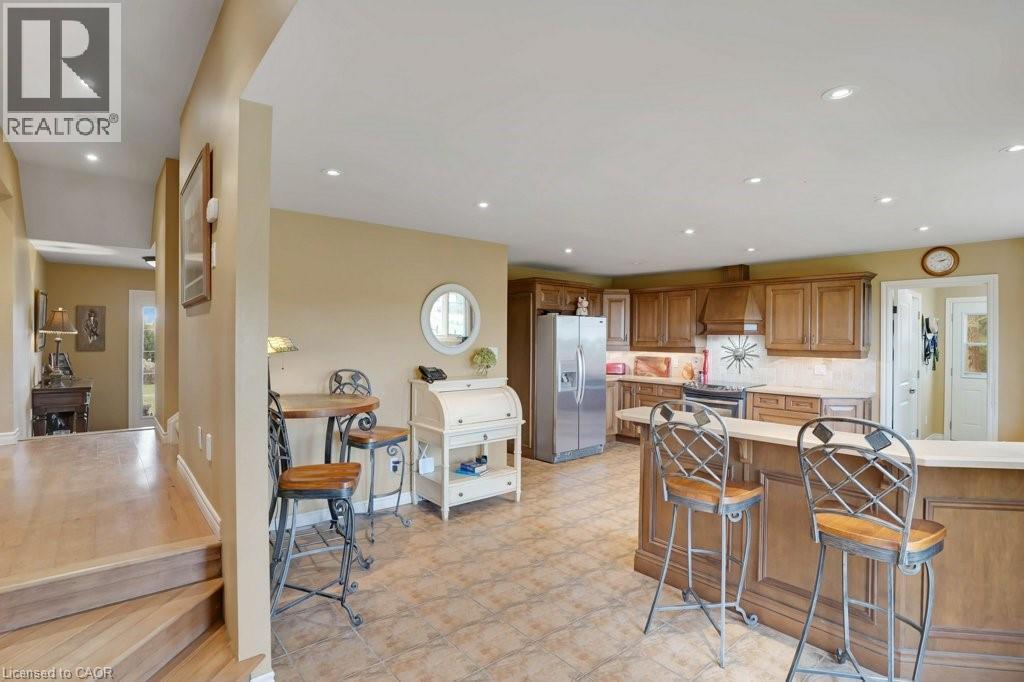 Kitchen with wood finish cabinets, stainless steel appliances, a breakfast bar, backsplash, and recessed lighting - 5511 Second Line, Erin, ON - Indoor