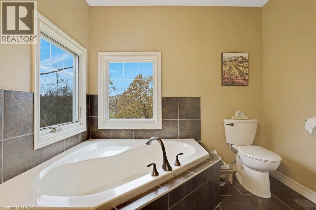 Bathroom featuring a garden tub and dark tile patterned flooring - 5511 Second Line, Erin, ON - Indoor Photo Showing Bathroom