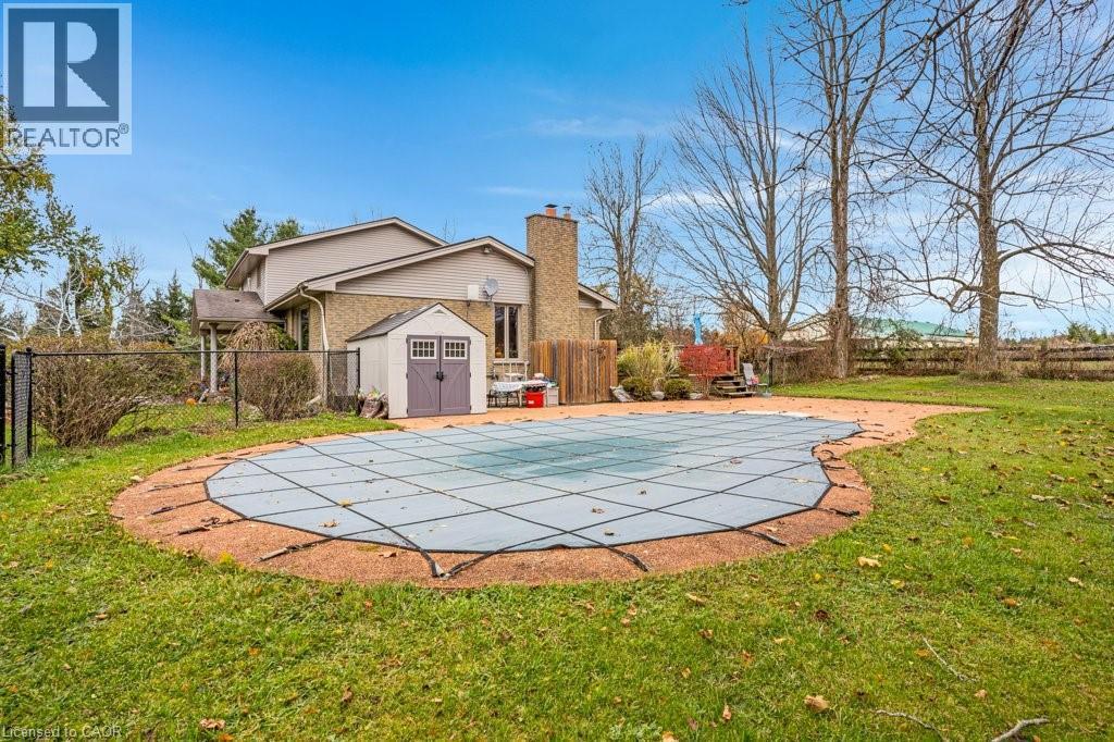 View of pool featuring a storage unit, a fenced backyard, and patio surround - 5511 Second Line, Erin, ON - Outdoor