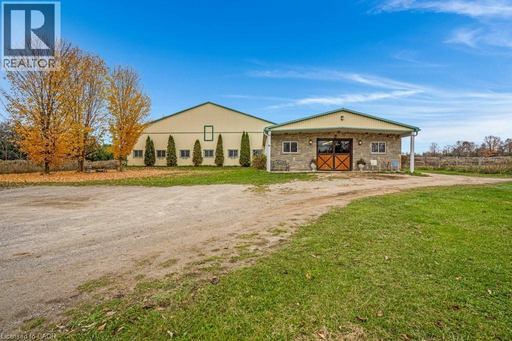 View of front facade featuring an outbuilding, a front lawn, and stone siding - 5511 Second Line, Erin, ON - Outdoor With Deck Patio Veranda