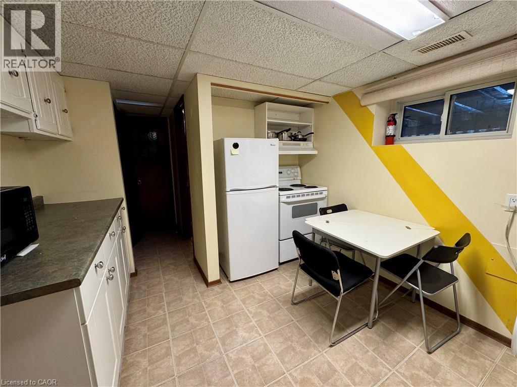 Kitchen with white appliances, dark countertops, white cabinets, a drop ceiling, and open shelves - 86 Devonglen Drive, Kitchener, ON - Indoor Photo Showing Kitchen