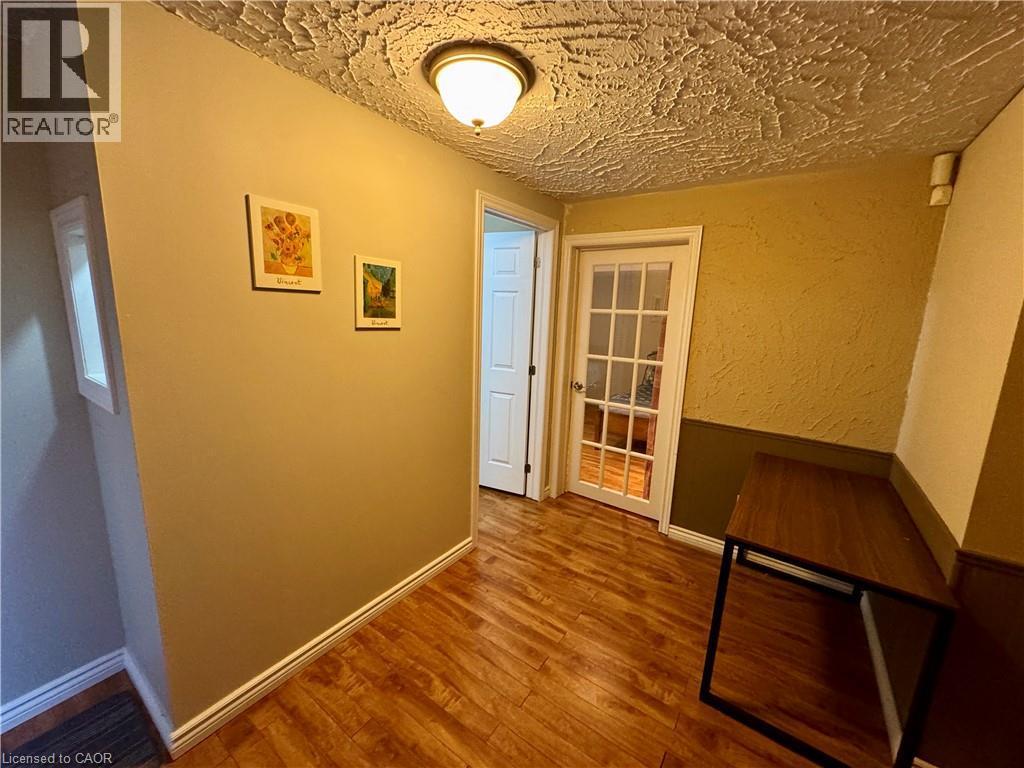 Hallway featuring a textured wall and wood-type flooring - 86 Devonglen Drive, Kitchener, ON - Indoor Photo Showing Other Room