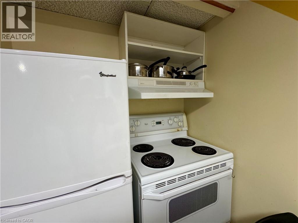 Kitchen featuring white appliances and under cabinet range hood - 86 Devonglen Drive, Kitchener, ON - Indoor Photo Showing Kitchen