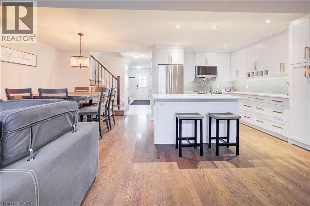 Kitchen featuring white cabinets, a breakfast bar, appliances with stainless steel finishes, hanging light fixtures, and recessed lighting - 34 Harrison Street, Stratford, ON - Indoor