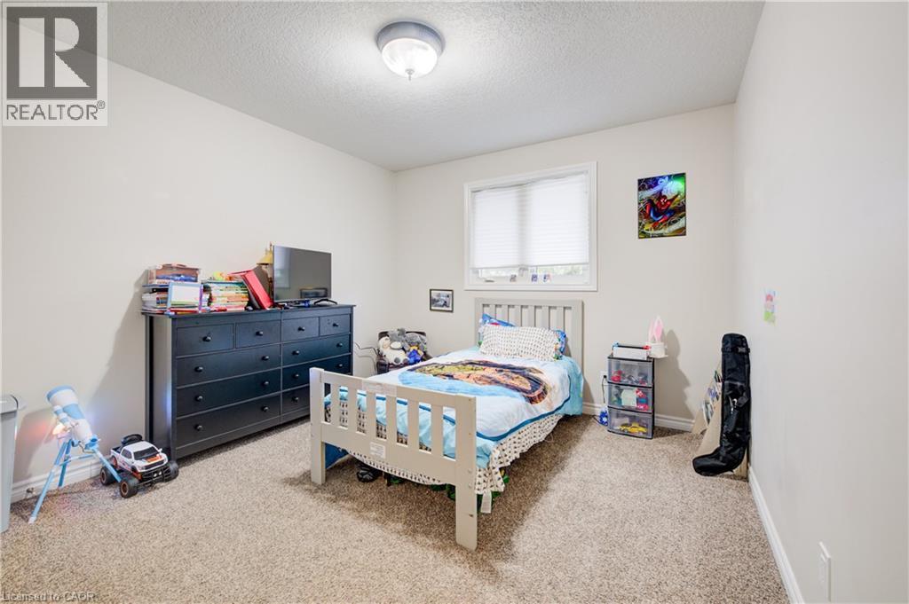 Carpeted bedroom with a textured ceiling and baseboards - 34 Harrison Street, Stratford, ON - Indoor Photo Showing Bedroom