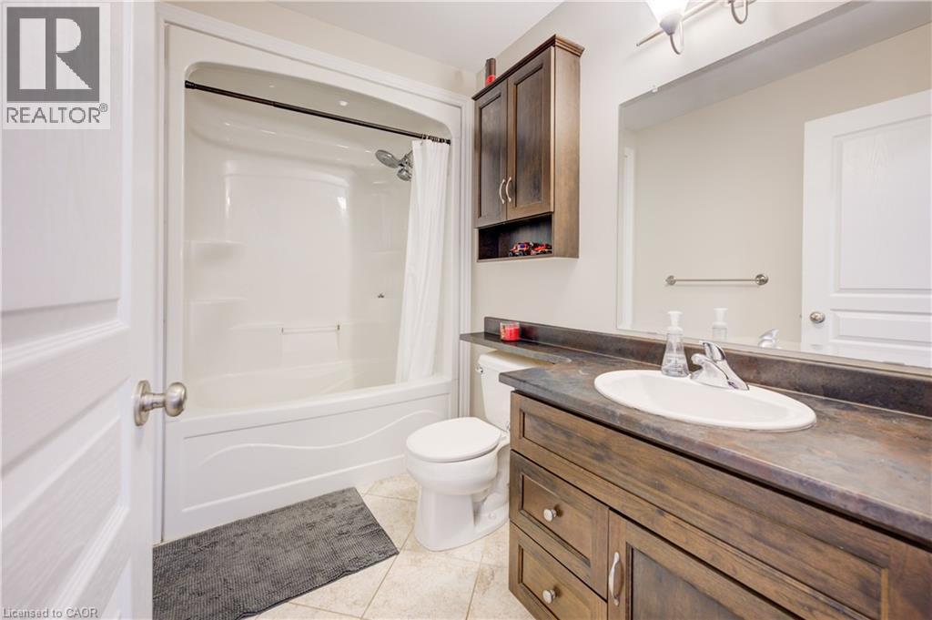 Full bathroom featuring shower / bath combo, vanity, and light tile patterned floors - 34 Harrison Street, Stratford, ON - Indoor Photo Showing Bathroom