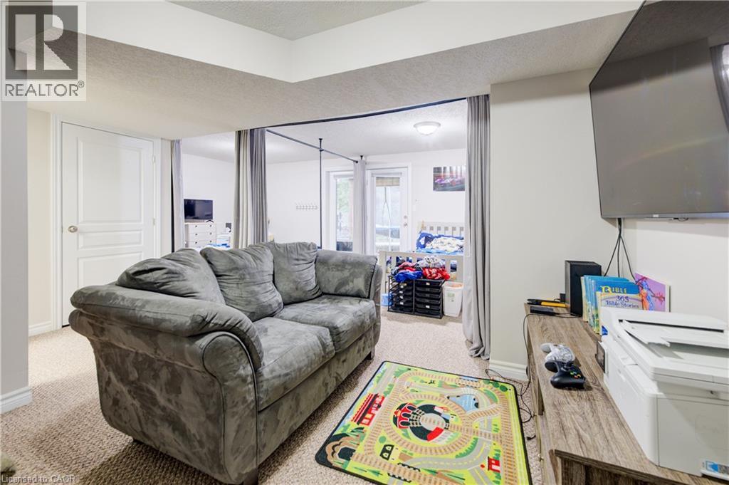 Living room featuring a textured ceiling and carpet flooring - 34 Harrison Street, Stratford, ON - Indoor Photo Showing Living Room