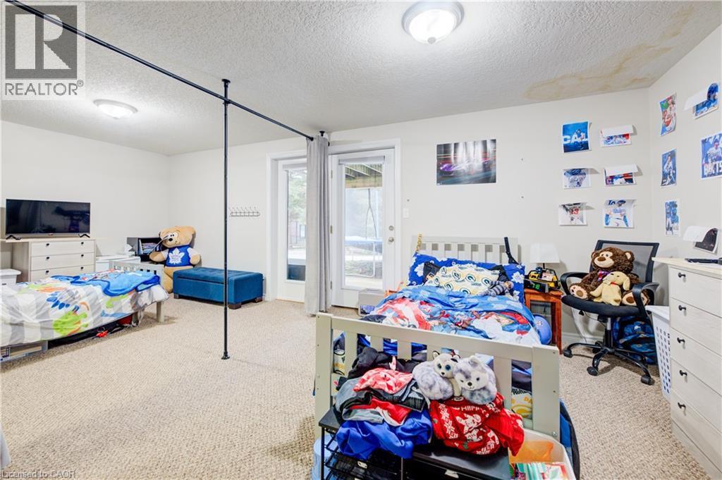 Bedroom with carpet floors, a textured ceiling, and access to exterior - 34 Harrison Street, Stratford, ON - Indoor Photo Showing Bedroom