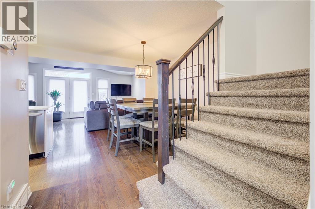 Dining room featuring dark wood-style floors, stairway, and a chandelier - 34 Harrison Street, Stratford, ON - Indoor