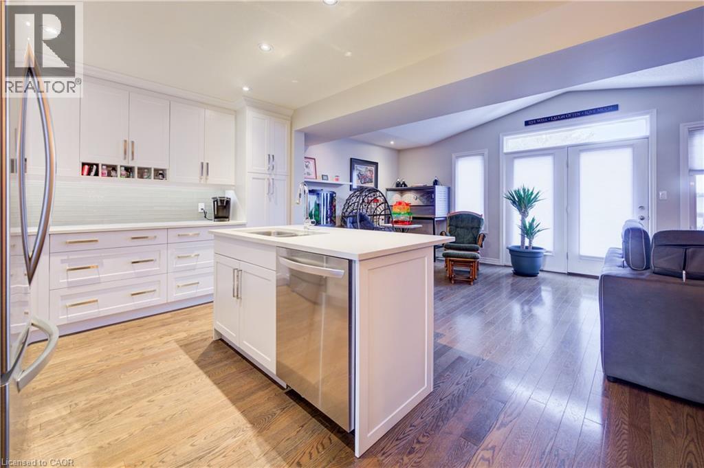 Kitchen with open floor plan, white cabinetry, appliances with stainless steel finishes, vaulted ceiling, and recessed lighting - 34 Harrison Street, Stratford, ON - Indoor Photo Showing Kitchen