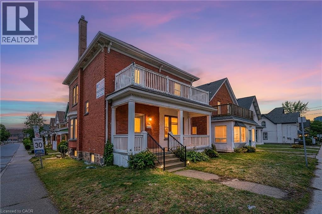 View of front facade with brick siding, a chimney, a balcony, a front yard, and a porch - 30 Regina Street N, Waterloo, ON - Outdoor