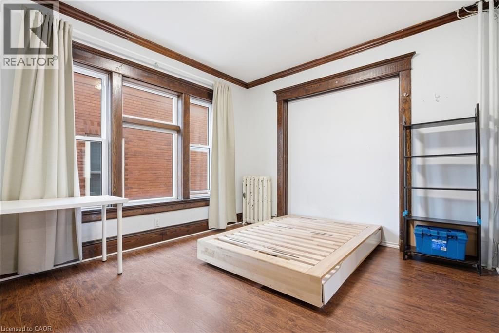 Bedroom featuring crown molding, dark wood finished floors, and radiator - 30 Regina Street N, Waterloo, ON - Indoor Photo Showing Bedroom