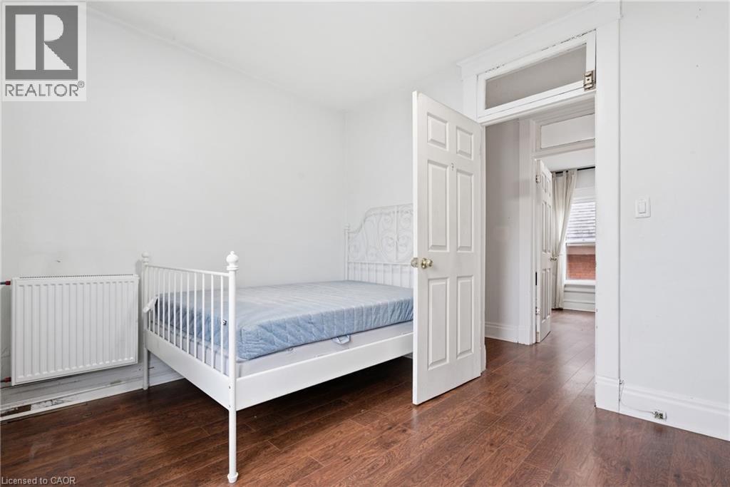Bedroom with radiator and dark wood-style floors - 30 Regina Street N, Waterloo, ON - Indoor Photo Showing Bedroom