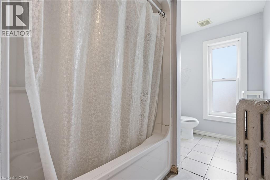 Full bathroom featuring shower / bath combo with shower curtain and light tile patterned floors - 30 Regina Street N, Waterloo, ON - Indoor Photo Showing Bathroom