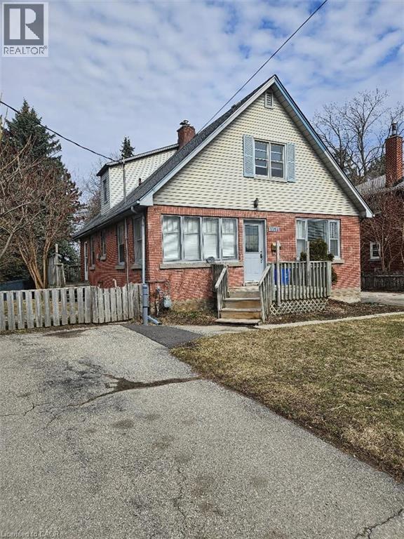 Bungalow-style home featuring brick siding and a chimney - 1154 Queens Boulevard, Kitchener, ON - Outdoor