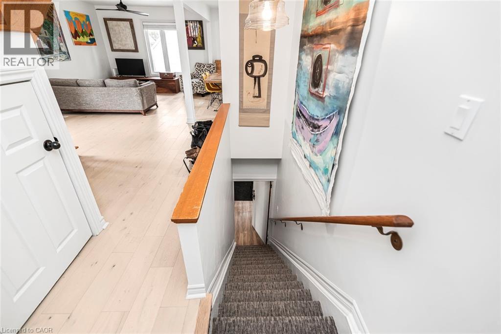 Stairway featuring wood finished floors and ceiling fan - 57 New Street, Hamilton, ON - Indoor Photo Showing Other Room