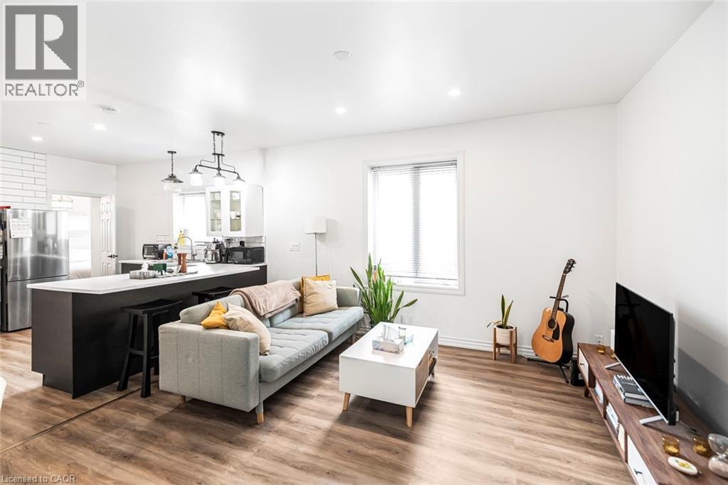 Living area with light wood-style floors, healthy amount of natural light, and recessed lighting - 57 New Street, Hamilton, ON - Indoor Photo Showing Other Room