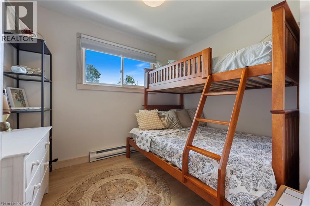 Bedroom with a baseboard heating unit and light wood-type flooring - 181 Cedar Drive, Turkey Point, ON - Indoor Photo Showing Bedroom