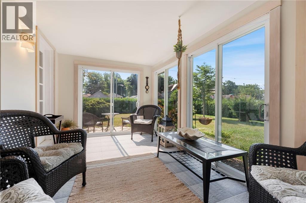 Sunroom featuring plenty of natural light and tile patterned floors - 181 Cedar Drive, Turkey Point, ON - Indoor Photo Showing Living Room