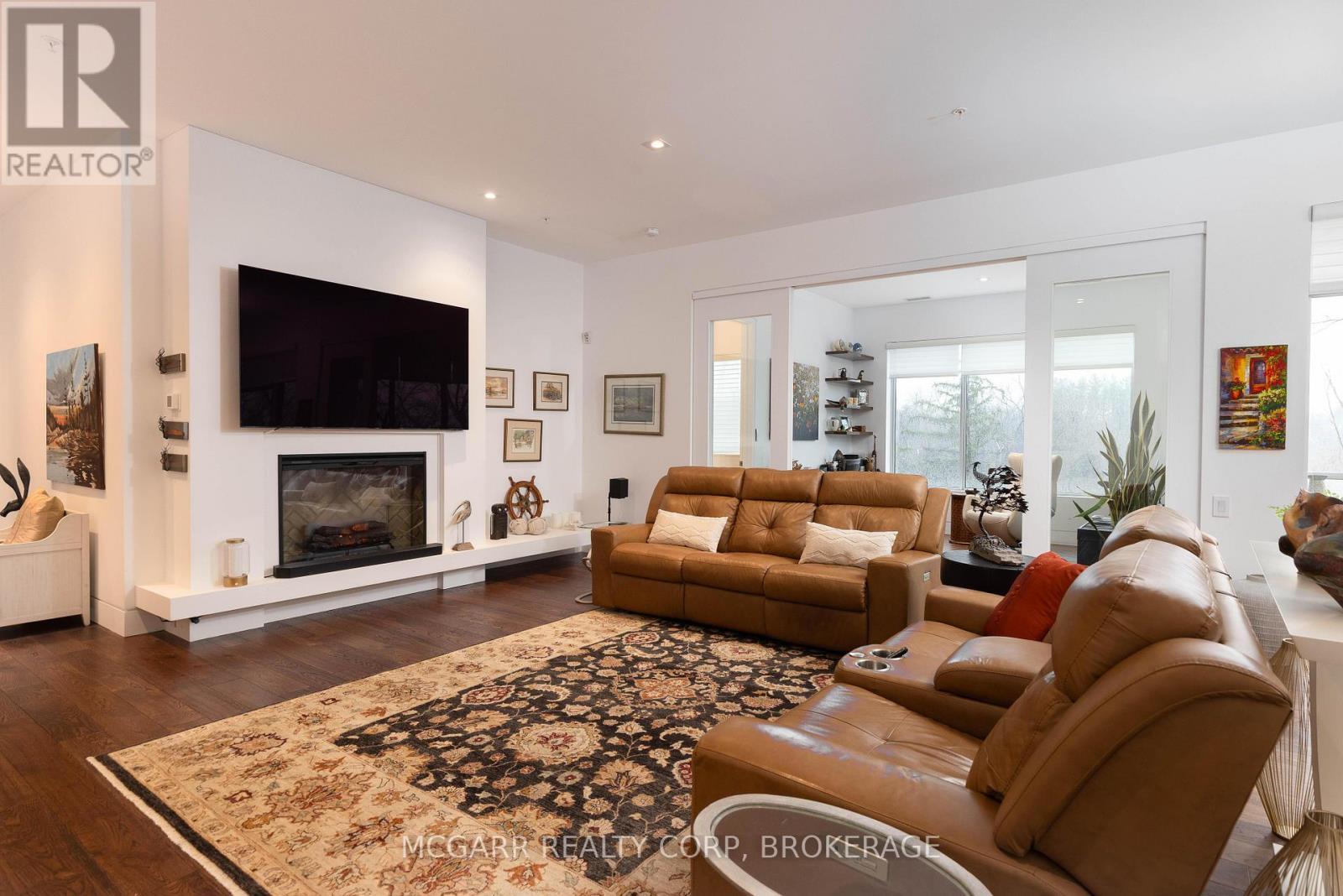 Fireplace + open to den/solarium - 401 - 77 Yates Street, St. Catharines (Downtown), ON - Indoor Photo Showing Living Room With Fireplace
